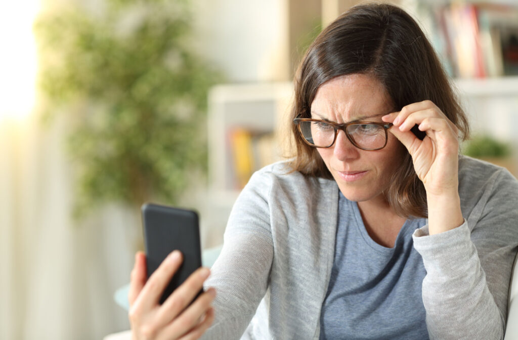 A middle-aged woman having trouble reading the contents of her phone.