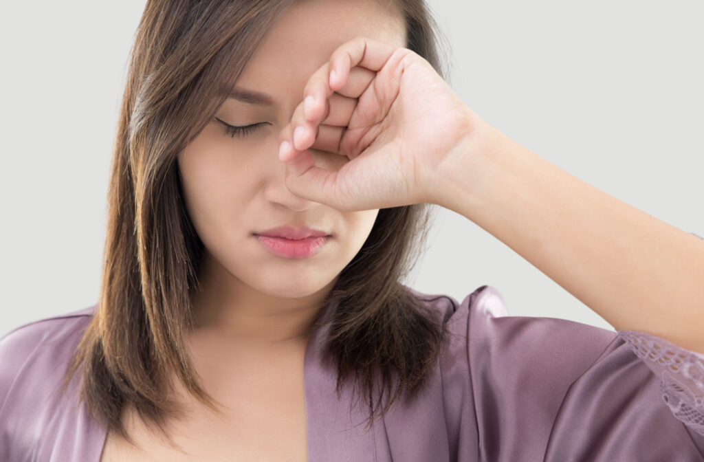 A woman rubbing her eye to dislodge the eyelash on her eye.