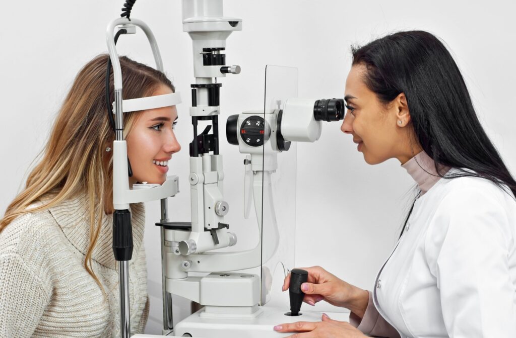 A smiling female optometrist is examining a female patient's eyes during a regular eye exam.