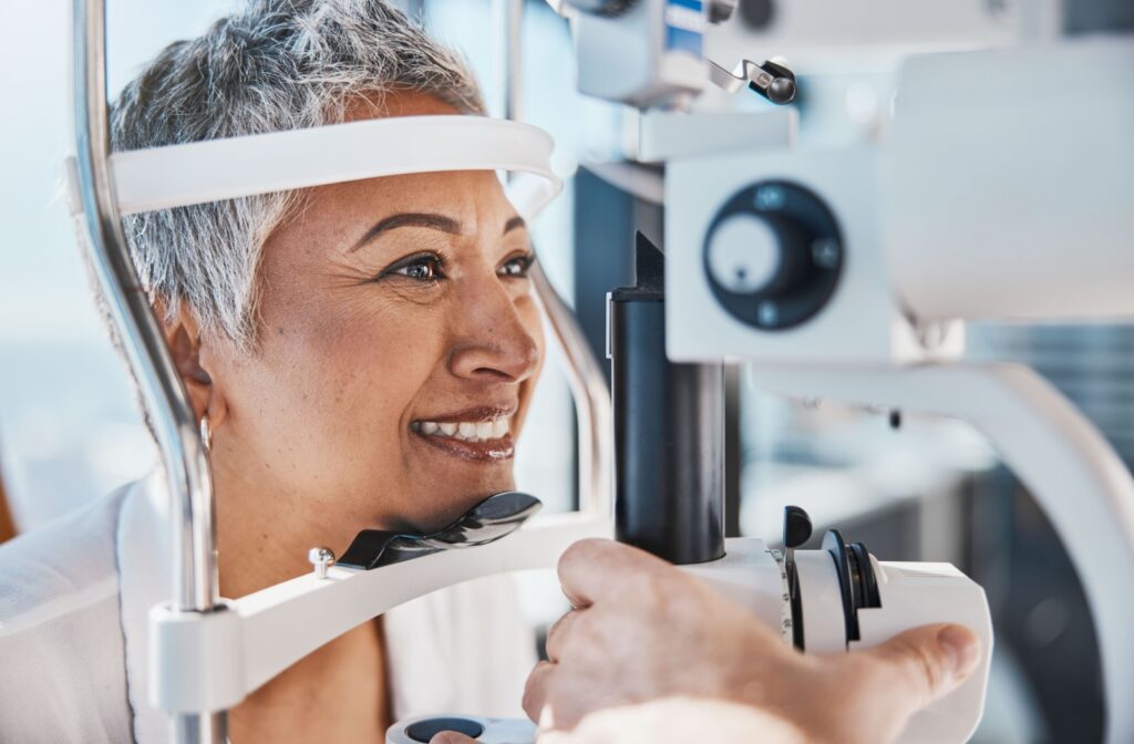 A senior woman smiling during her eye exam to find out if LASIK can fix her hyperopia.