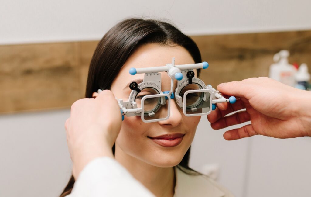An optometrist uses trial lenses to help determine a patient's exact prescription and measurments for a new pair of eyeglasses.