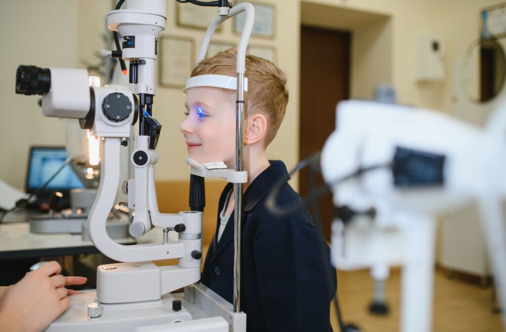 A young kid having their eyes examined by an optometrist during a kids eye exam.